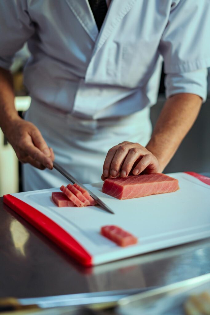 Chef skillfully slicing fresh tuna in a professional Tokyo kitchen, showcasing Japanese culinary art.